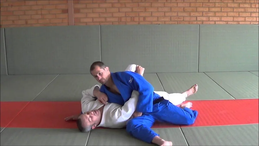 Illustrated sequence of Kuzure-kesa-gatame, the modified scarf hold.